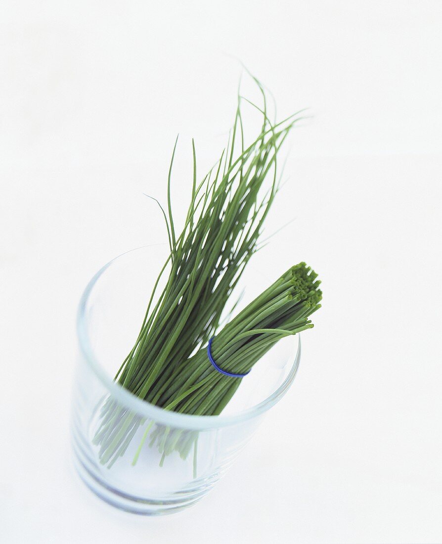 Halved bunch of chives in a glass