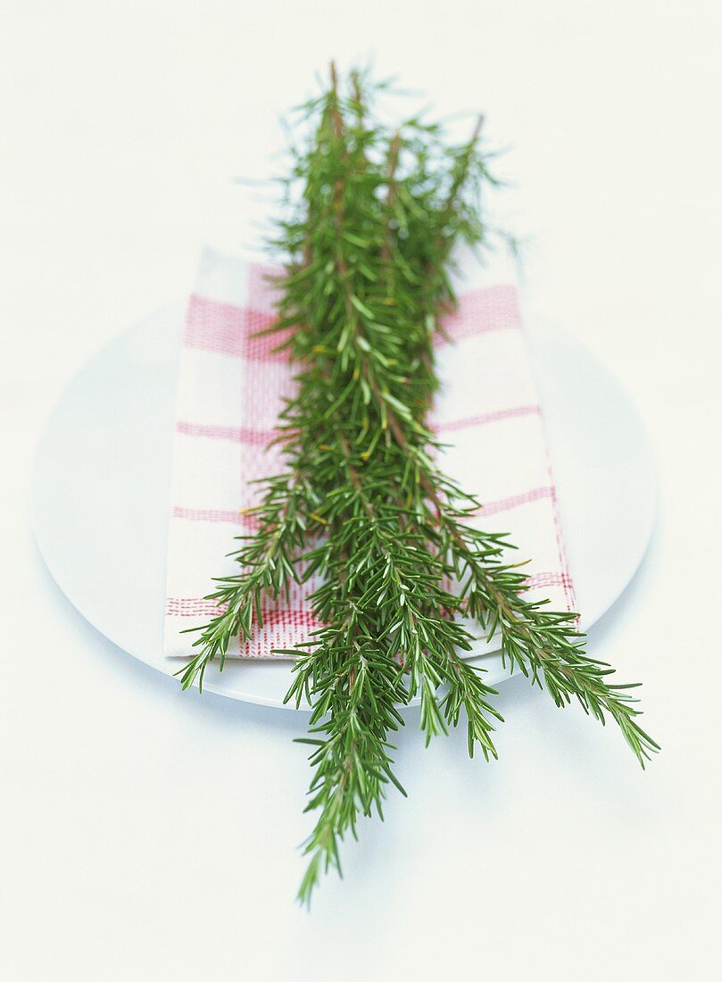 Sprigs of rosemary with tea towel on a plate