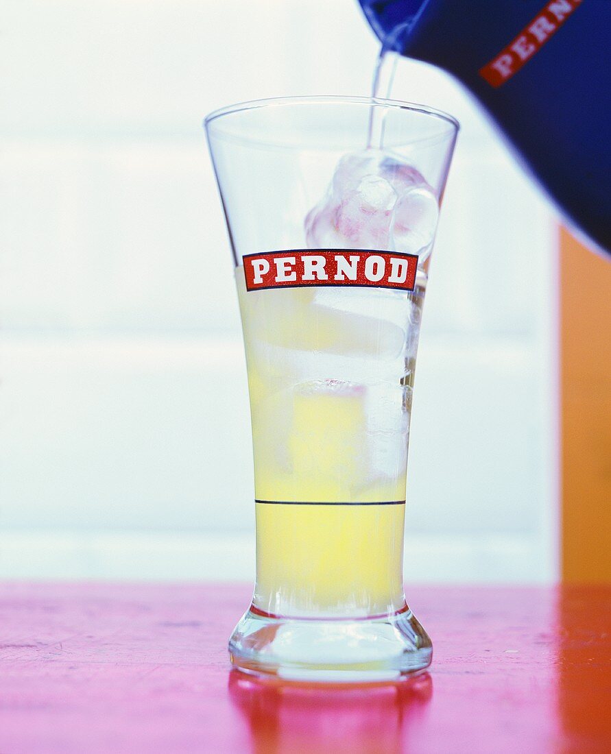 Pernod ins Glas eingiessen