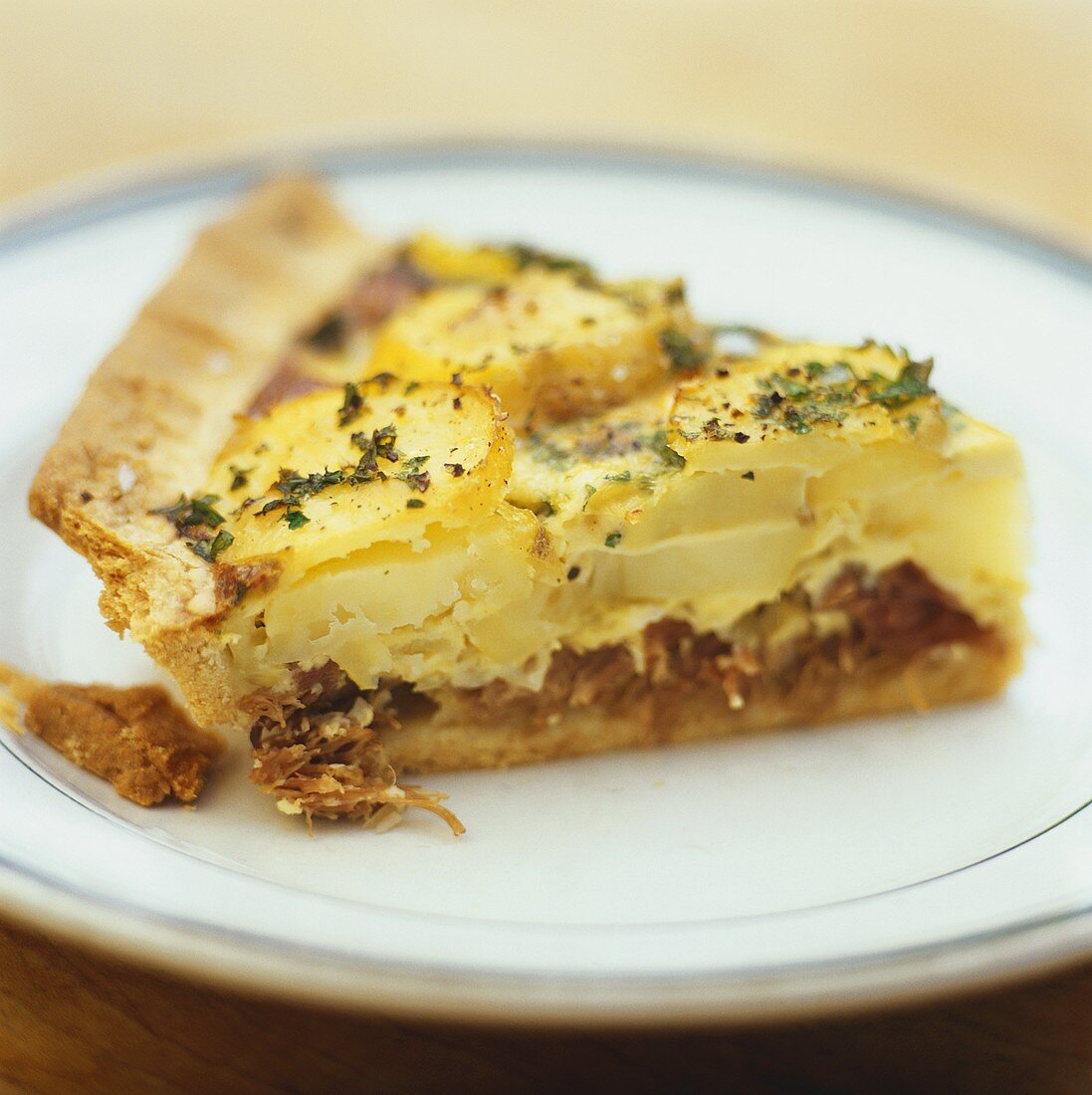 A slice of potato tart with duck confit