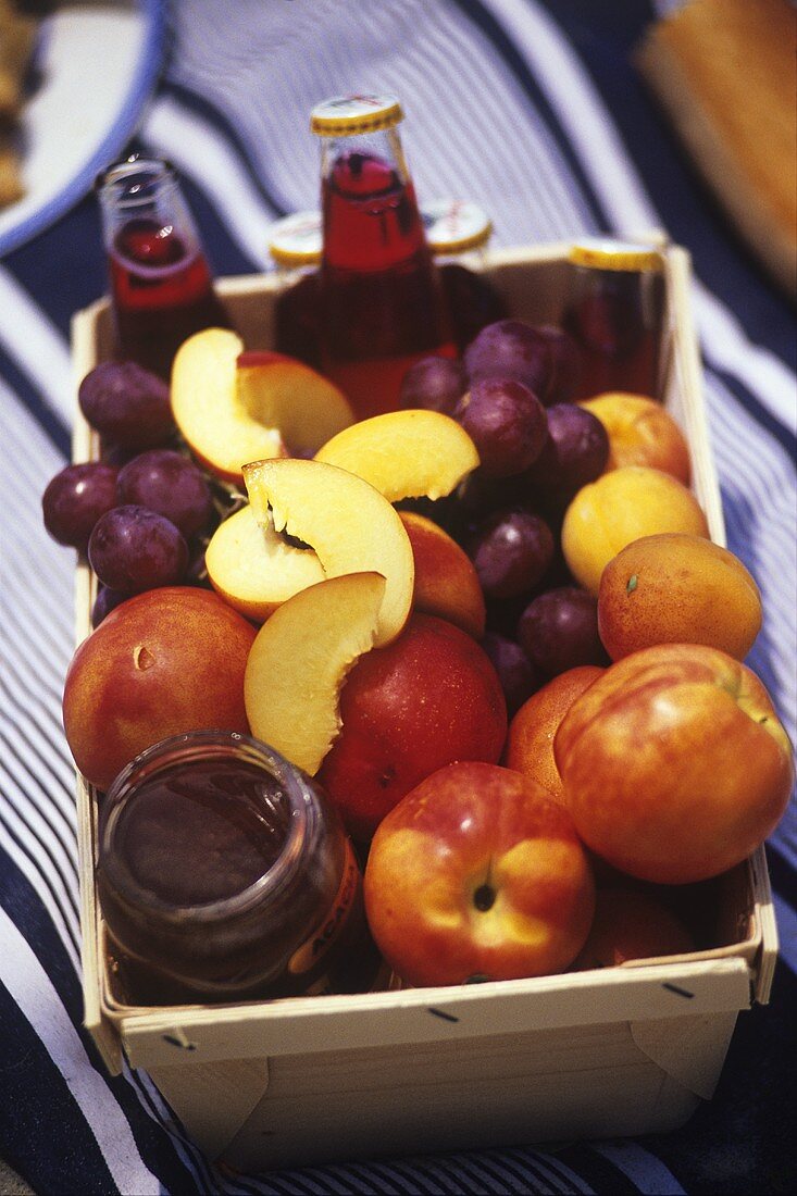 Früchte, Fruchtsäfte & Akazienhonig in einem Korb