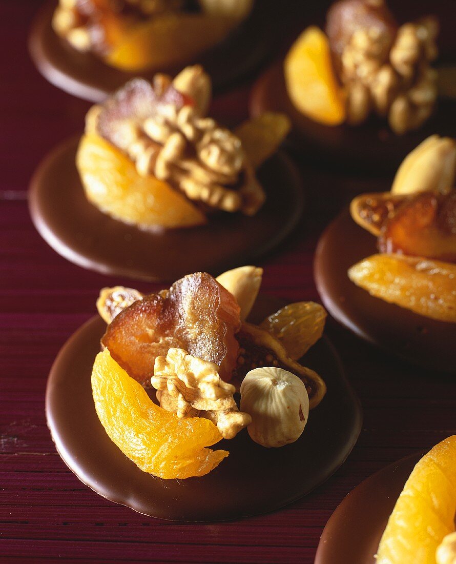 Chocolate rounds topped with fruit and nuts