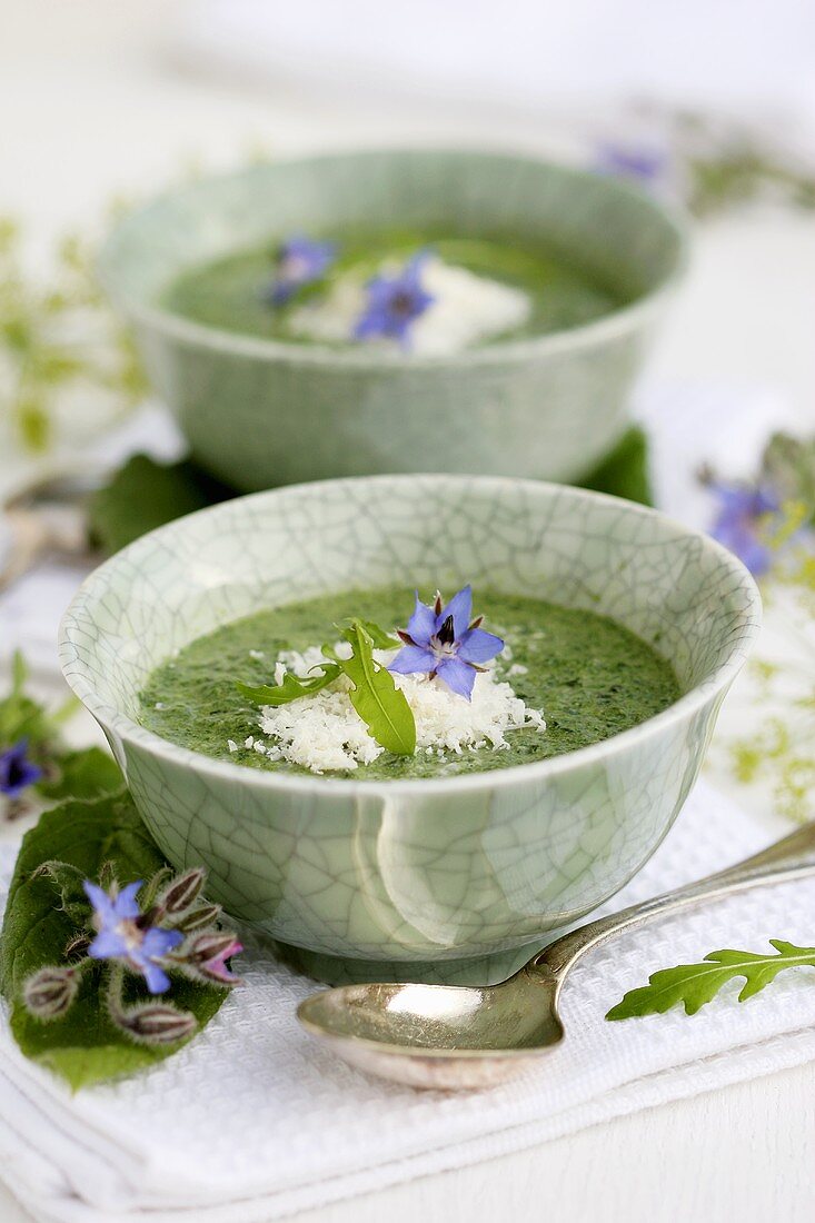 Borretschsuppe in Schälchen mit geriebenem Parmesan