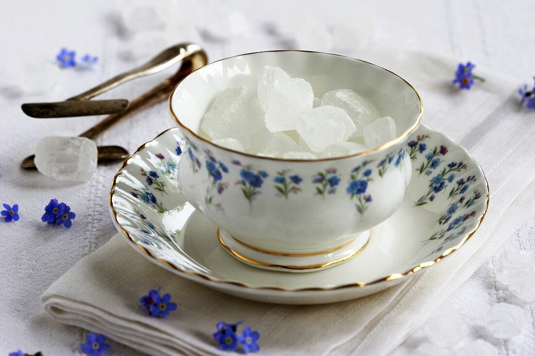 White sugar crystals in small bowl with forget-me-nots