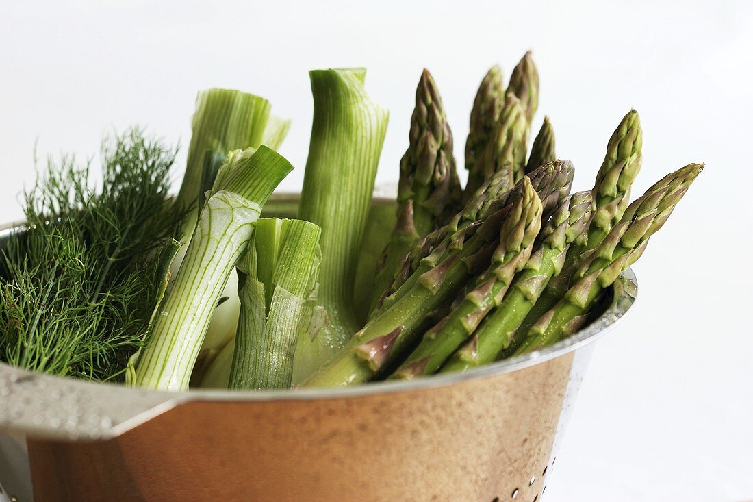 Dill, fennel and green asparagus in a colander