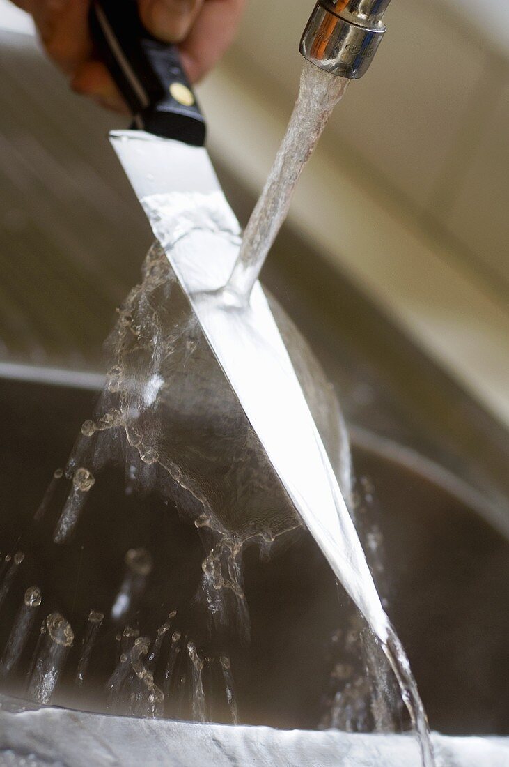 Rinsing a kitchen knife under running water