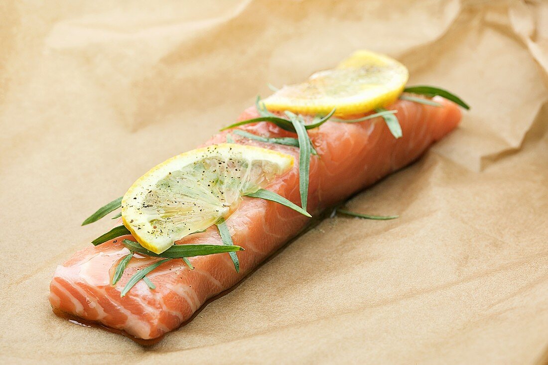 A piece of salmon fillet with tarragon and lemon slice