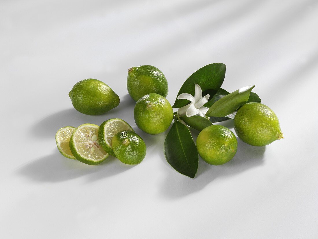 Limequats, whole and sliced with flower and leaves