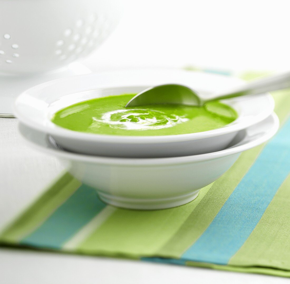 A plate of pea soup with spoon
