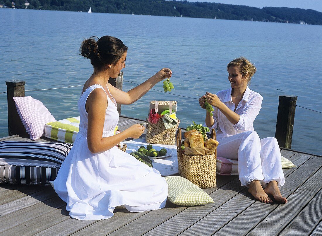 Two women picnicking on a landing stage