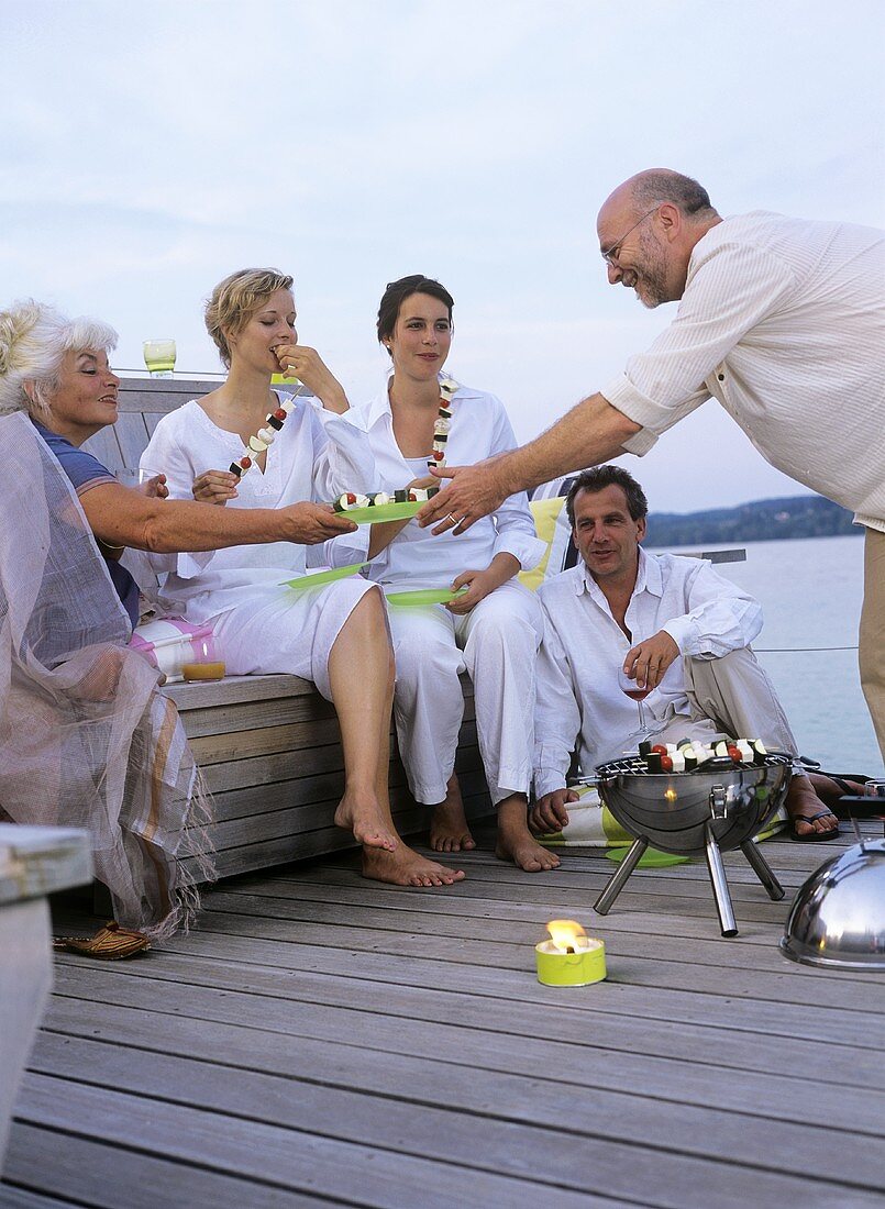 Several people having a barbecue on a landing stage