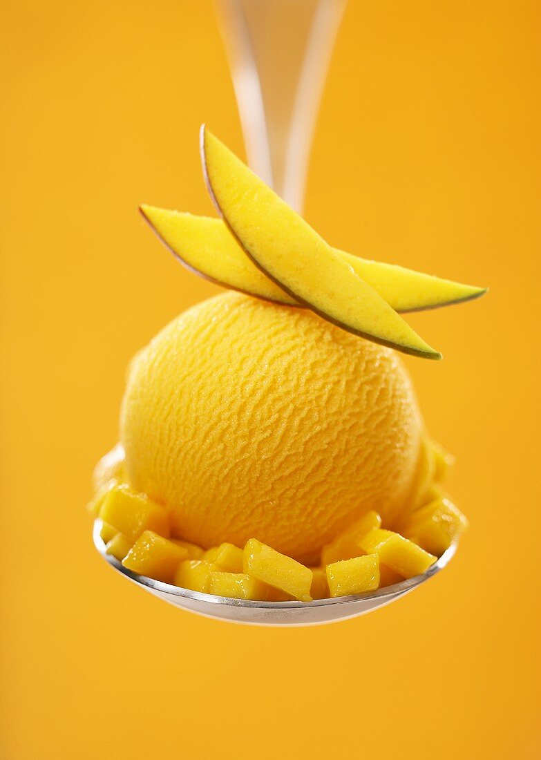 Mango sorbet with fresh fruit on a spoon