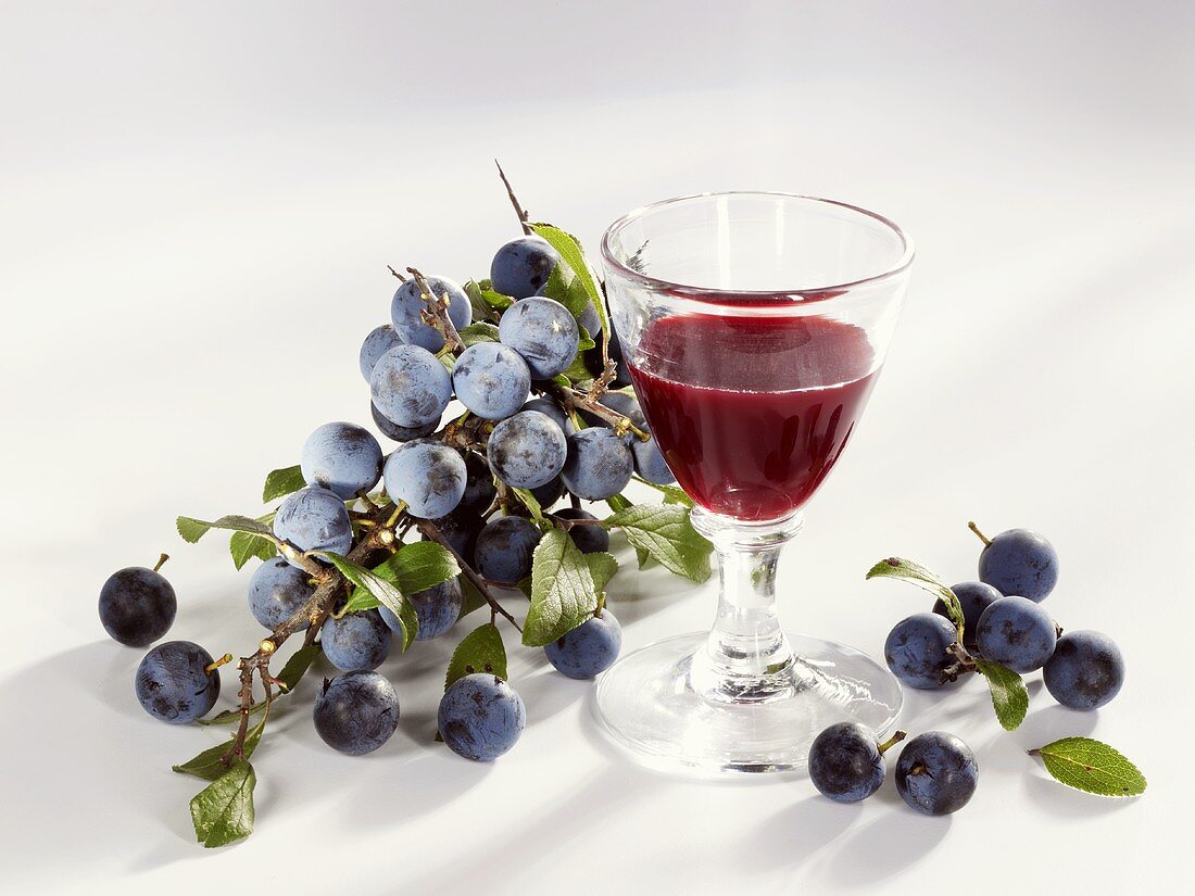 A glass of sloe liqueur and sloes