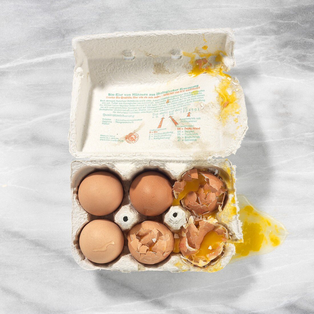 Three whole and three broken eggs in a box