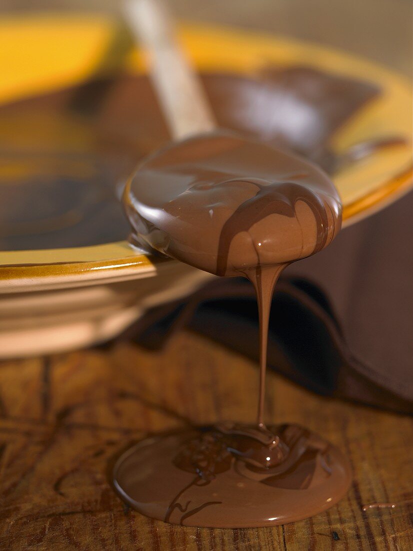 Melted chocolate running from a wooden spoon