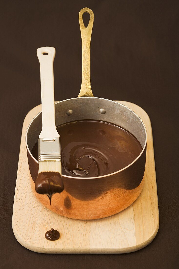 Geschmolzene Schokolade im Topf mit Pinsel