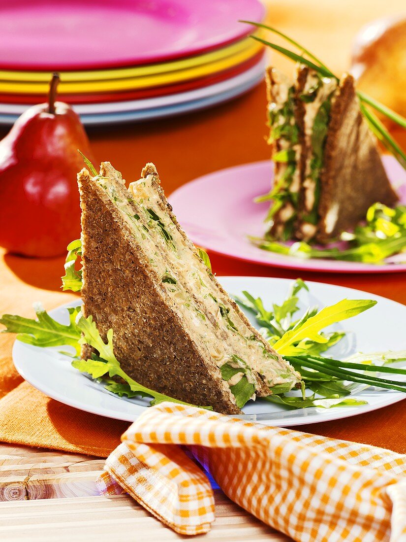 Rocket and soft cheese sandwiches in pumpernickel bread