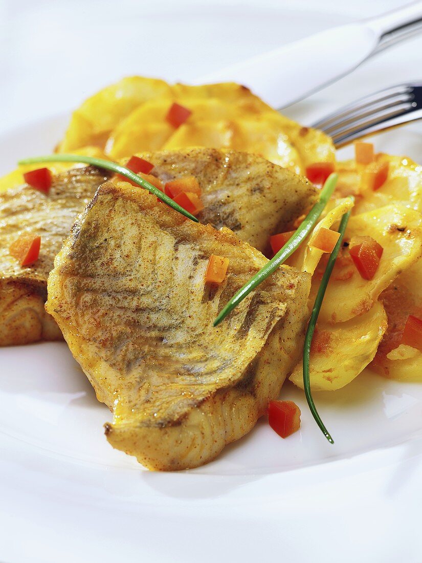 Fried fish fillet with diced peppers and potato gratin