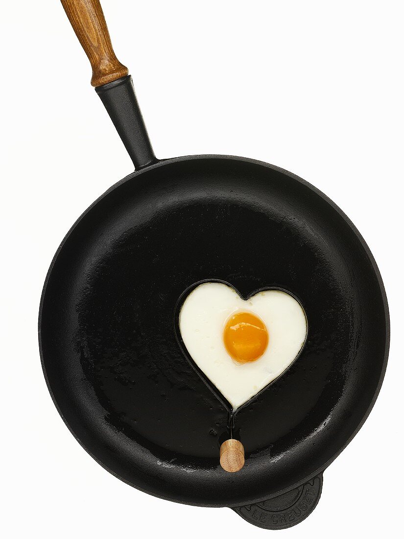 Heart-shaped fried egg in frying pan