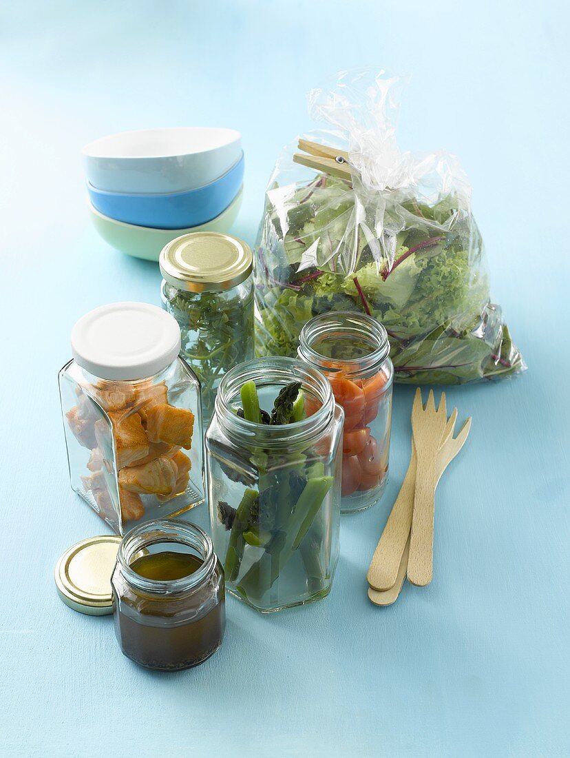 Various salad ingredients in jars for a picnic