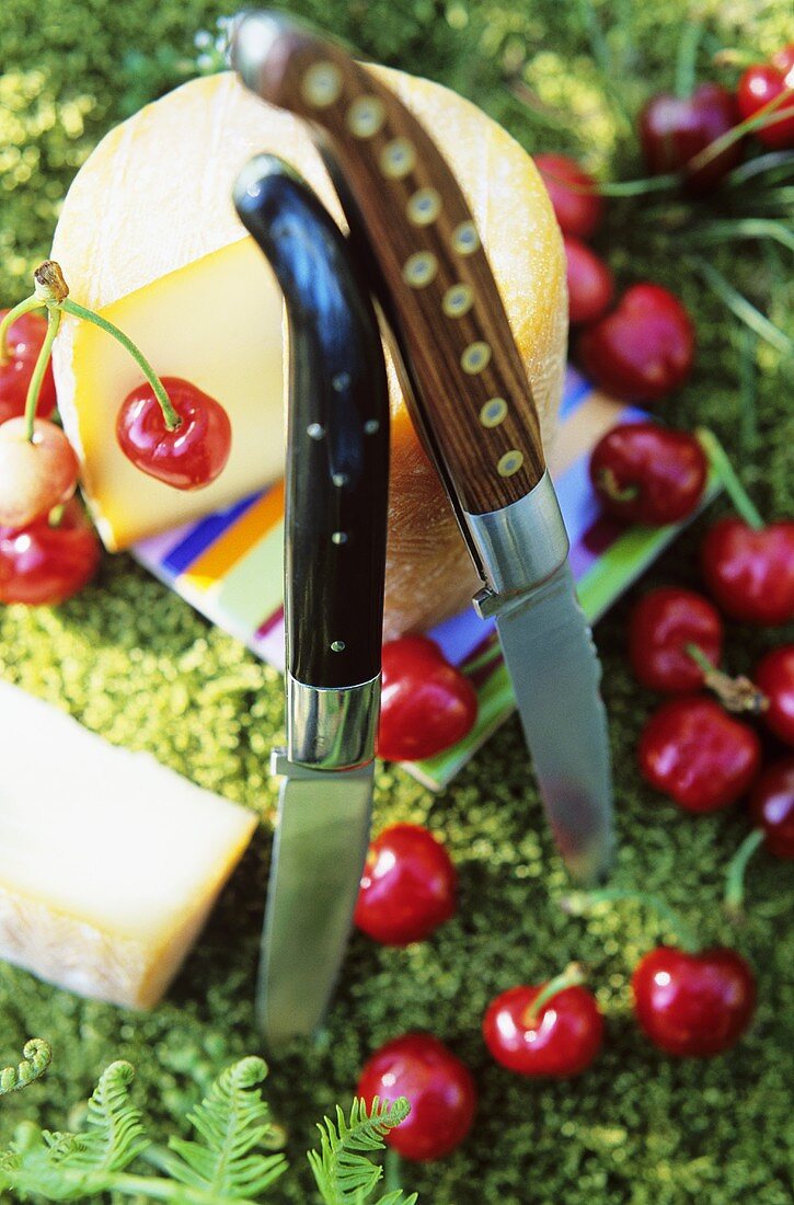 Goat's cheese, two knives and cherries