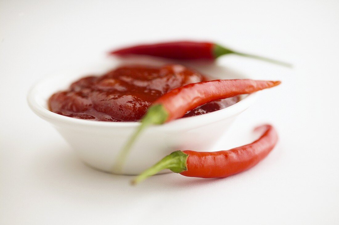 Chilli sauce in a small bowl with chillies