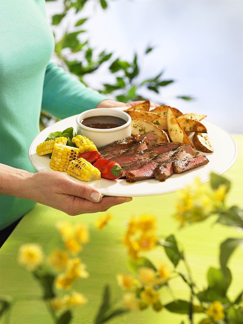 Roast beef with potato wedges, grilled vegetables and dip