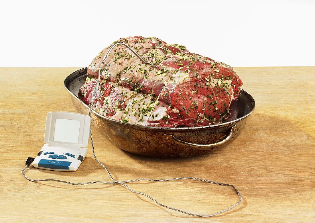 Prime rib in roasting dish with meat thermometer