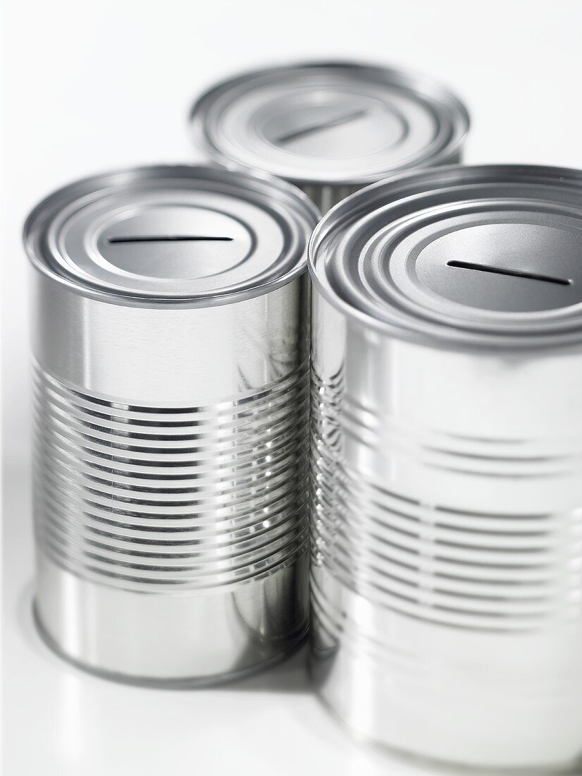 Three empty food tins with slots in the top