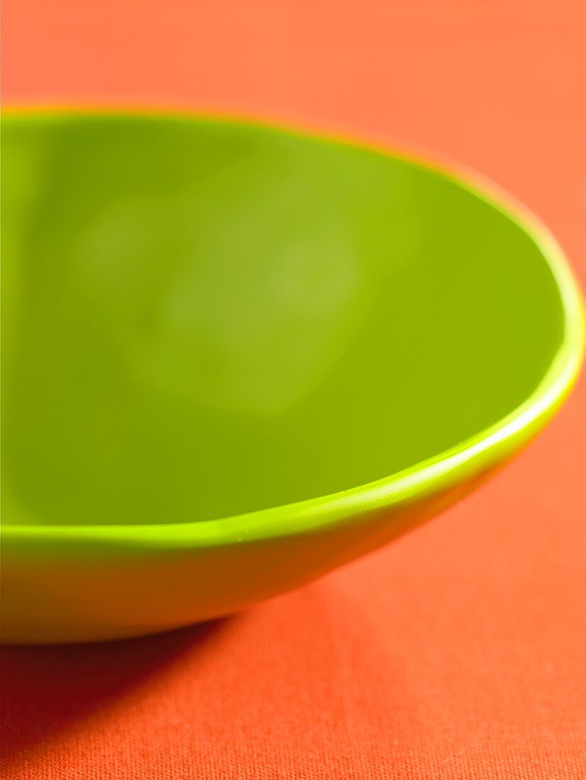 A green bowl on an orange background