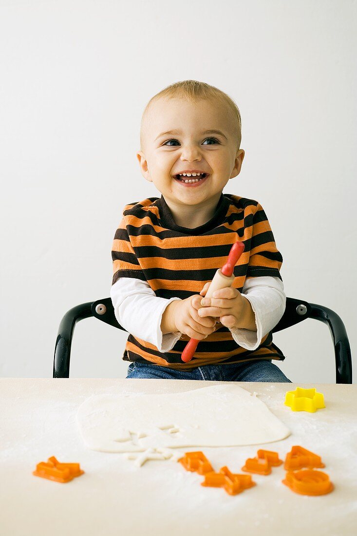 Small boy cutting out biscuits