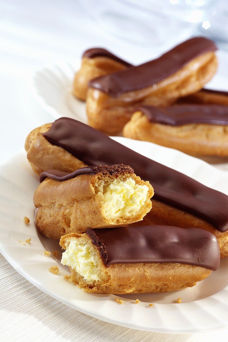 Eclairs mit Schokoladenglasur auf zwei Teller