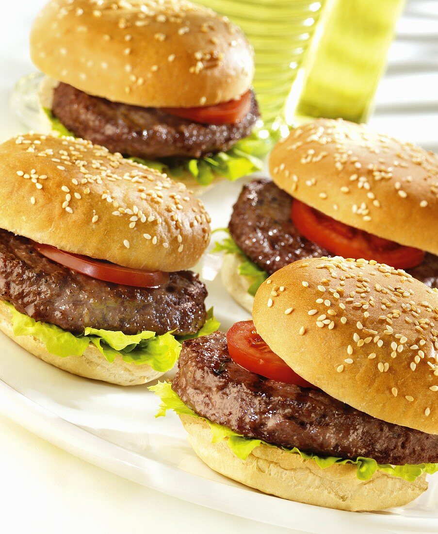 Four hamburgers with tomato and lettuce leaf