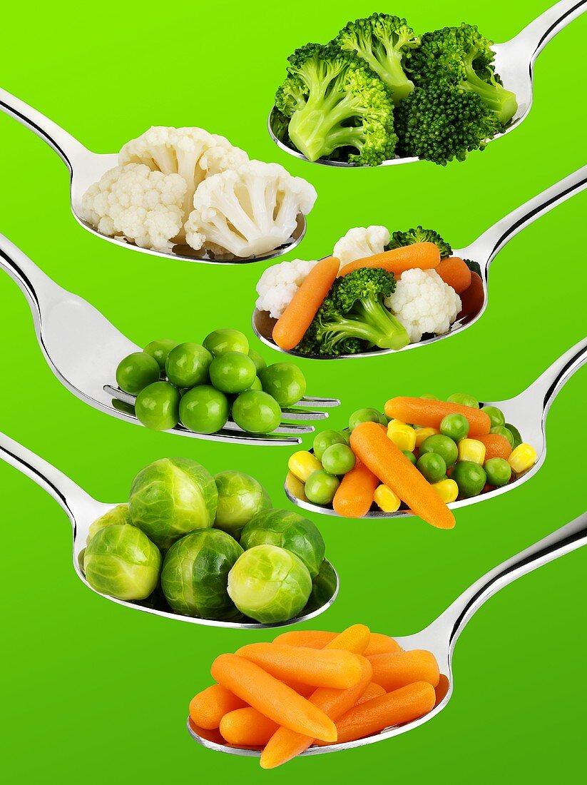 Various vegetables on spoons and forks