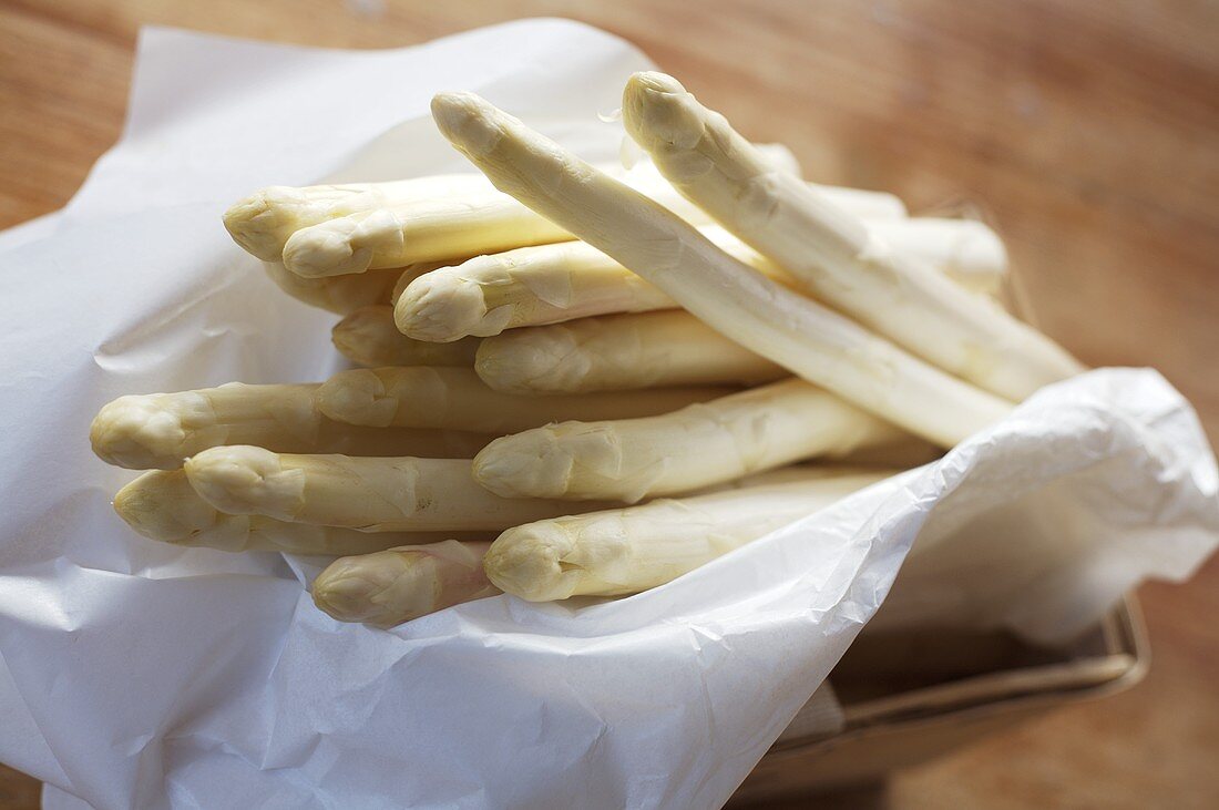 White asparagus with greaseproof paper in small basket