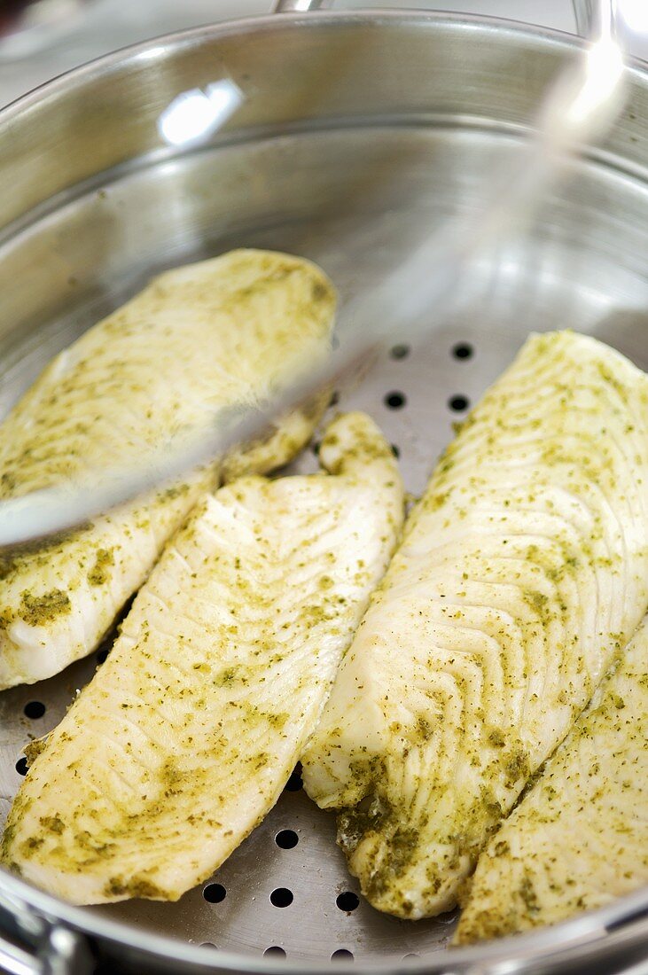 Cod with herbs in steamer pan
