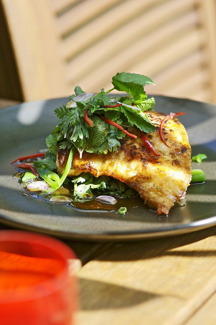 Fried fish fillet with herb salad