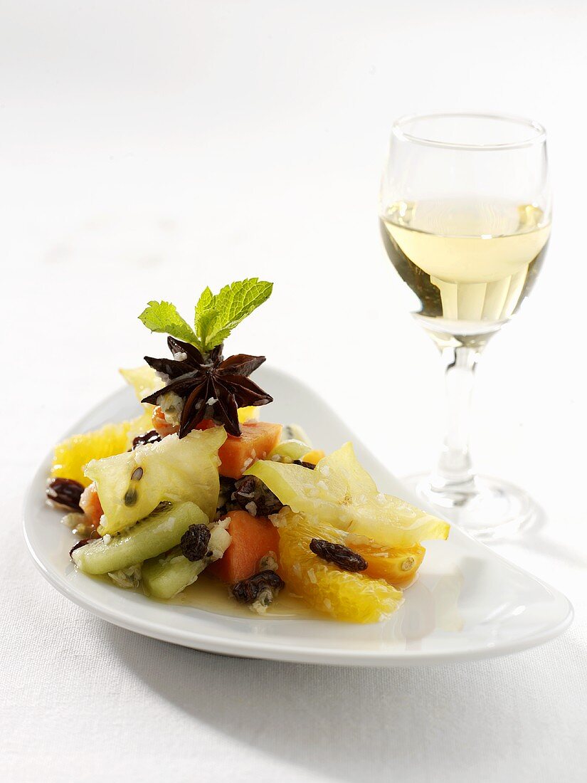 Exotic fruit salad on a platter with wine