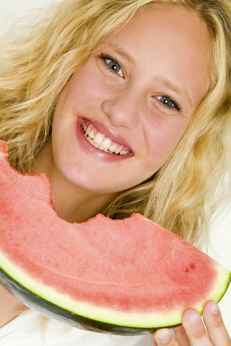 Blond woman eating a slice of watermelon