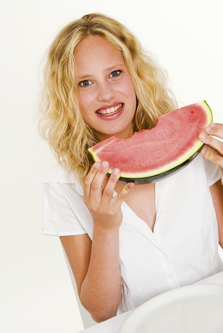 Blond woman eating a slice of watermelon