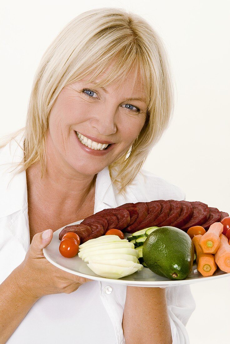 Woman holding a plate of vegetables