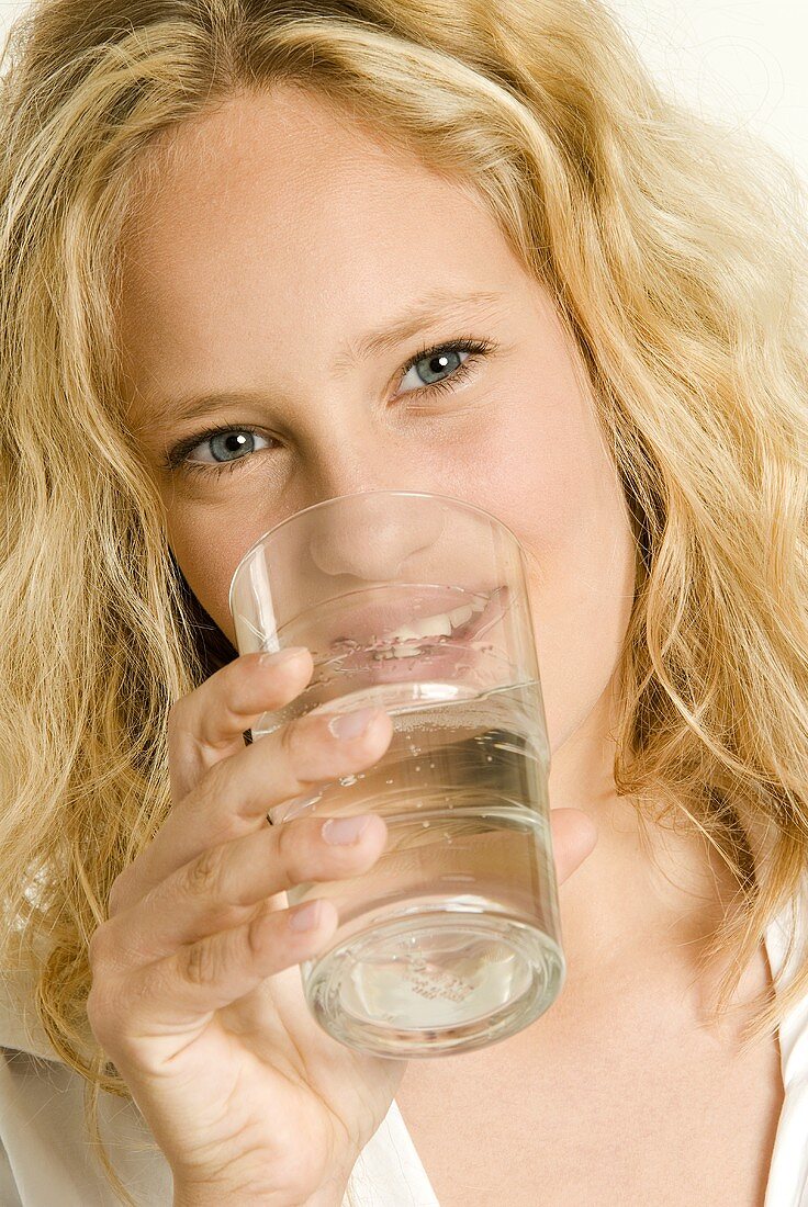 Young woman drinking mineral water from a glass