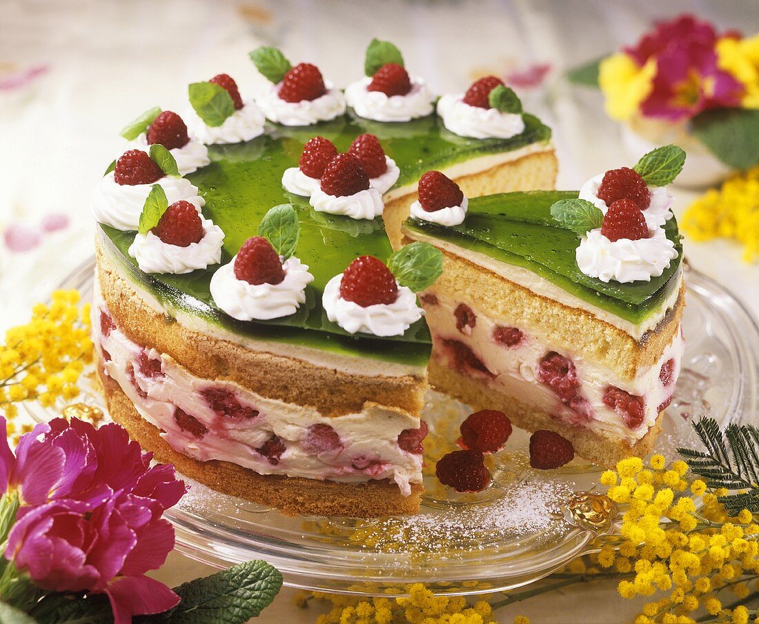 Raspberry cream cake topped with green jelly