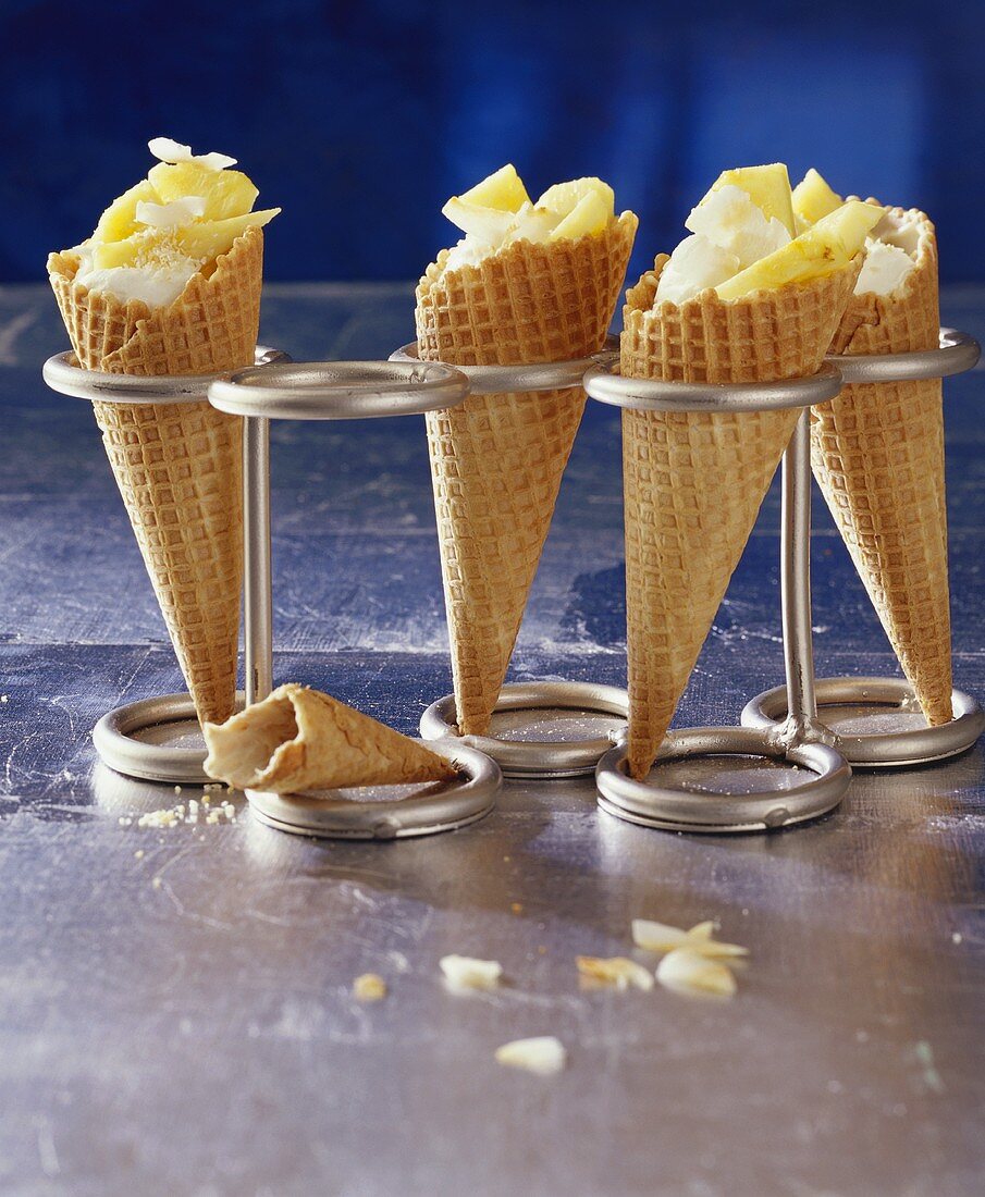 Pineapple ice cream, pineapple pieces & grated coconut in 4 waffle cones