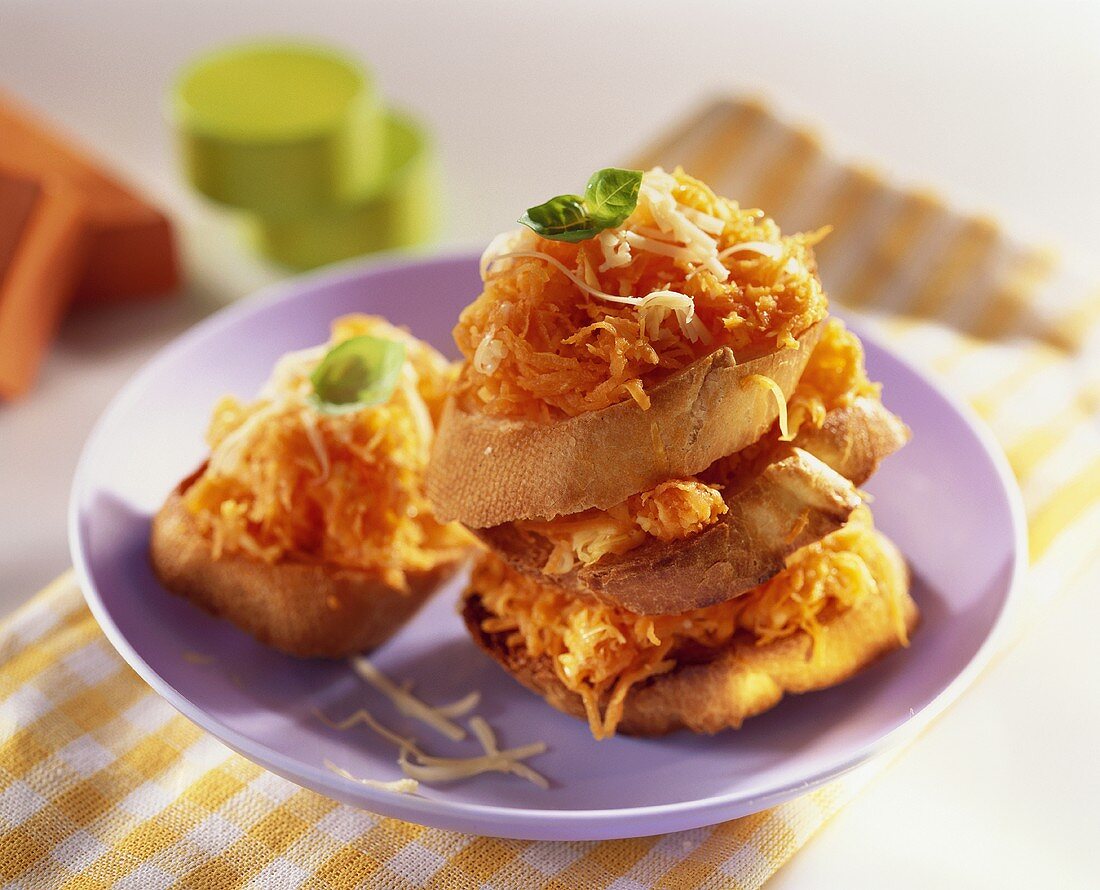 Crostini topped with grated carrots and cheese