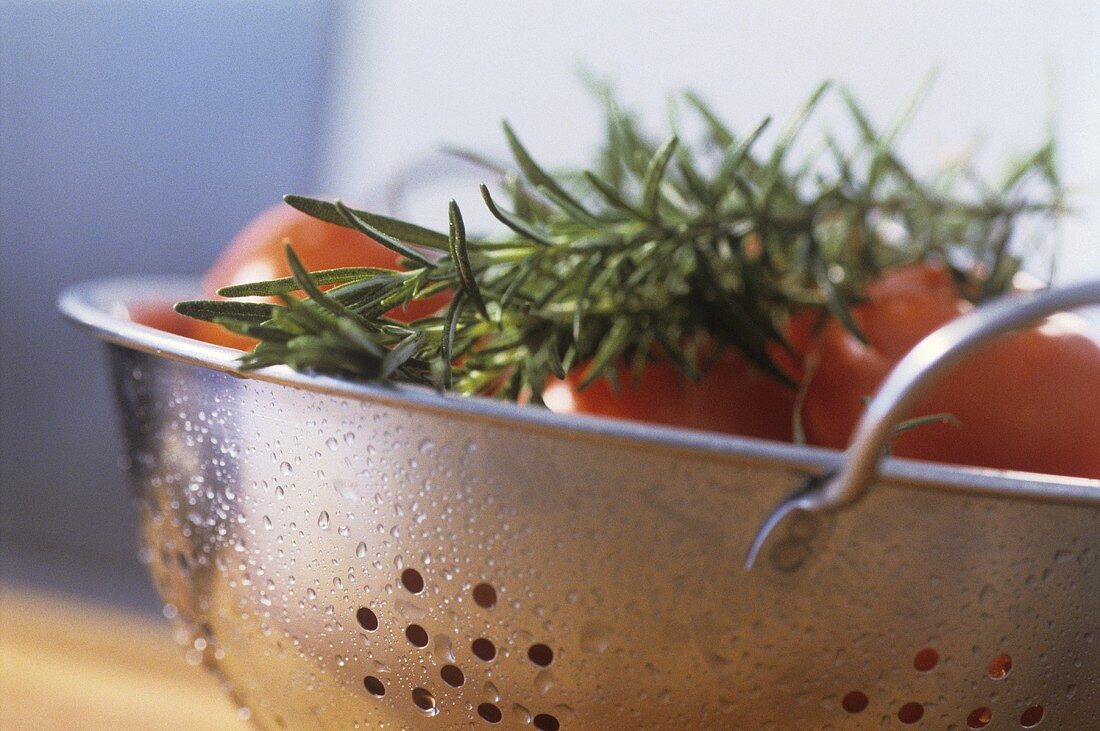 Tomaten und Rosmarin in einem Küchensieb