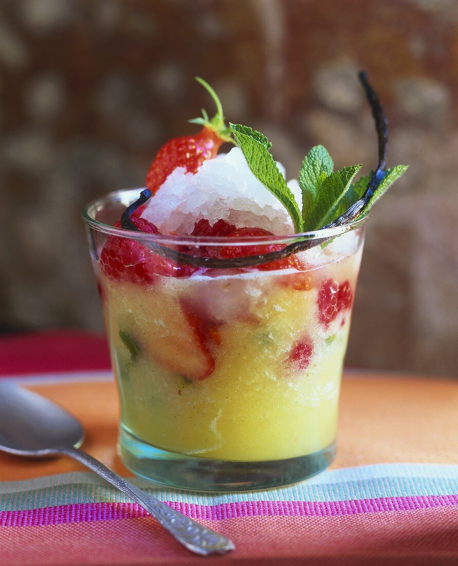 Ananassuppe mit roten Beeren und Minzgranité