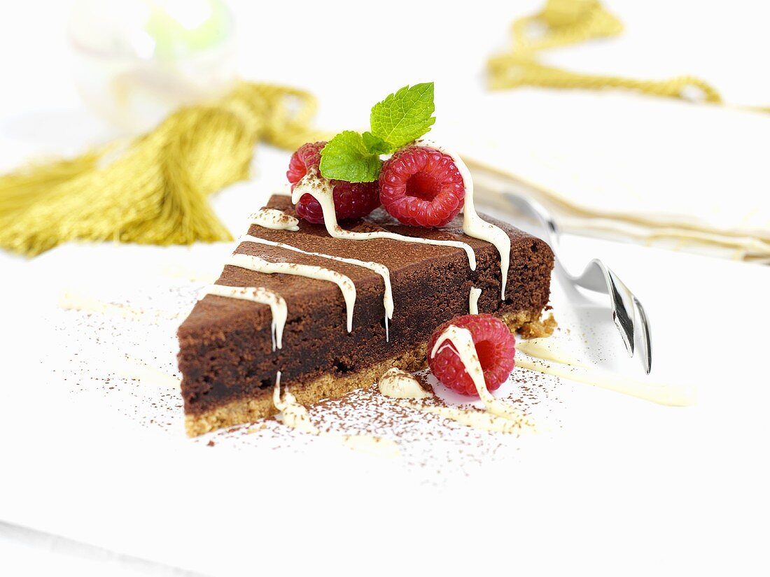 Ein Stück Chocolate-Fudge-Cake (England) mit Himbeeren