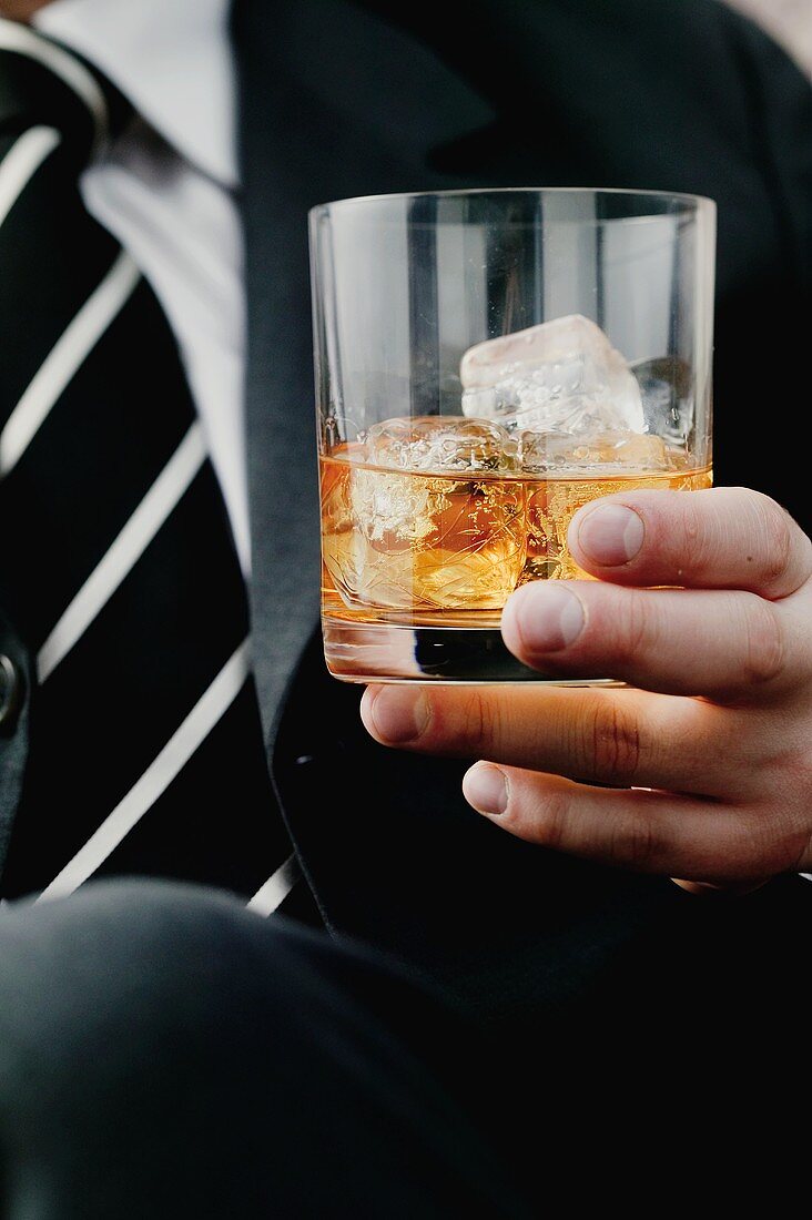 A glass of cognac with ice cubes