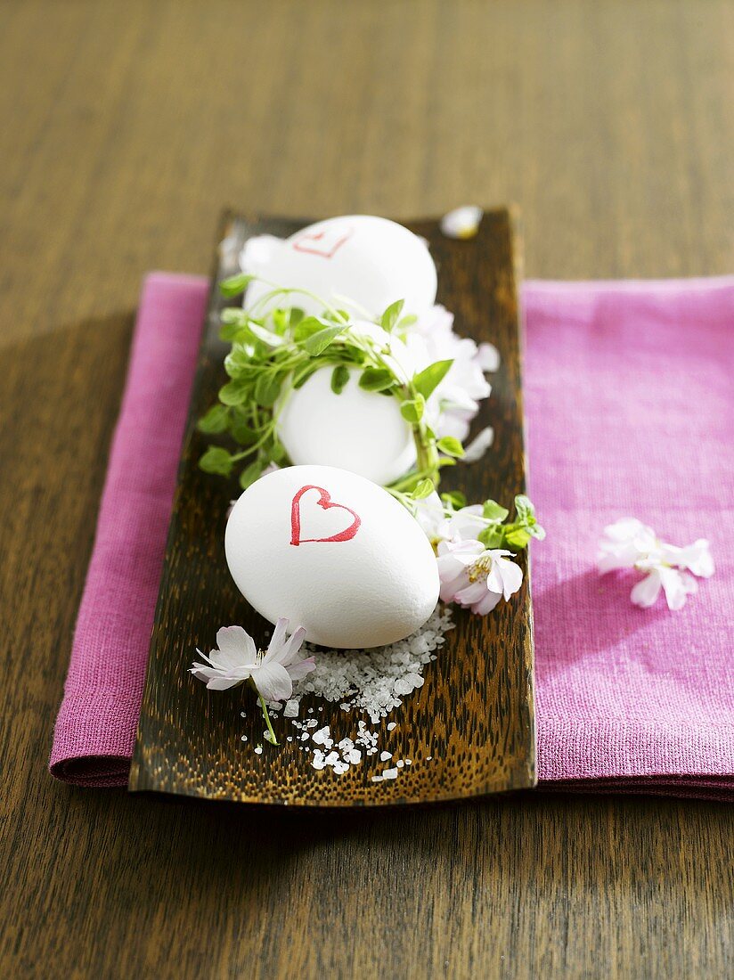 Frühstückseier in einer Schale mit Salz und Blüten